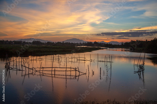 Beautiful sunset in Vietnam, fishing nets on the river, sunset on a background of mountains, Hoi An, Vietnam
