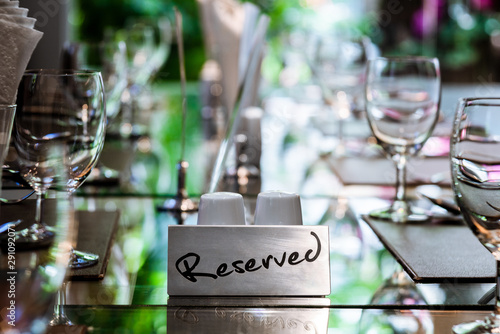 Reserved Metal Plate on the Table with Blurry background. Reservation Seat at restaurant.