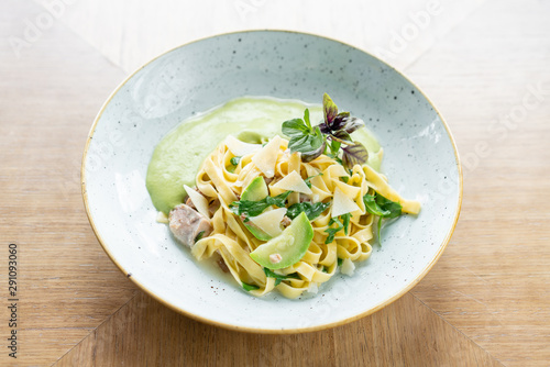 Italian pasta tagliatelle with zucchini, Turkey and green sauce. Parmesan cheese photo