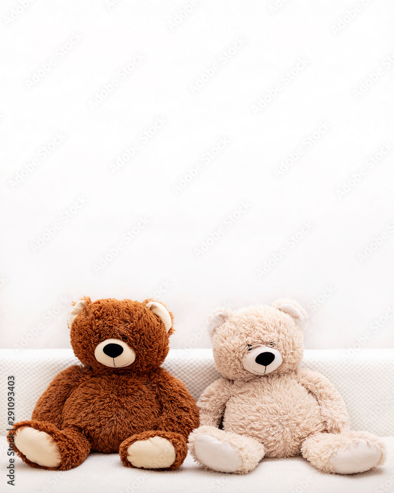 Children's toys - bears of brown and beige color are sitting on the sofa. Children's toys - bears of brown and beige color are sitting on the sofa.