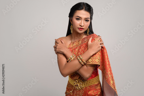 Beautiful Thai woman wearing Thai dress and standing hugging herself