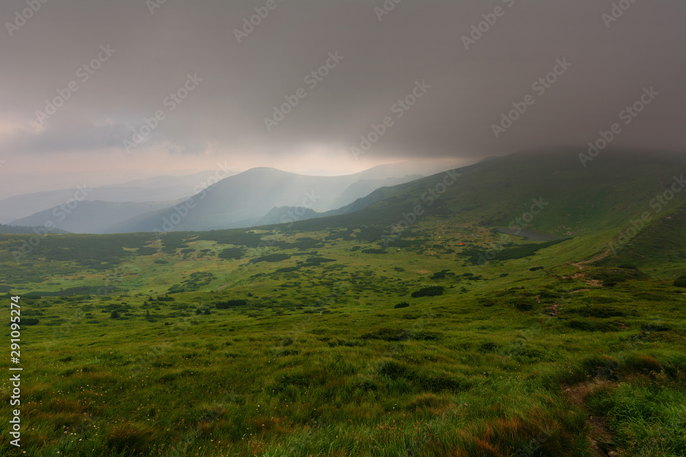 Mountain scenery with fog, rain, dramatic sky and beautiful scenery.