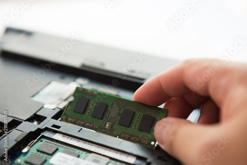Close-up view of technician open a cover and upgrade a notebook by add a new ram and remove old ram
