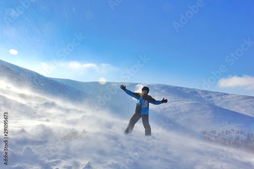 Man on top of mountain in blizzard 