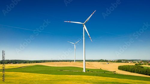 Flying above big wind turbine on field in sunny Poland