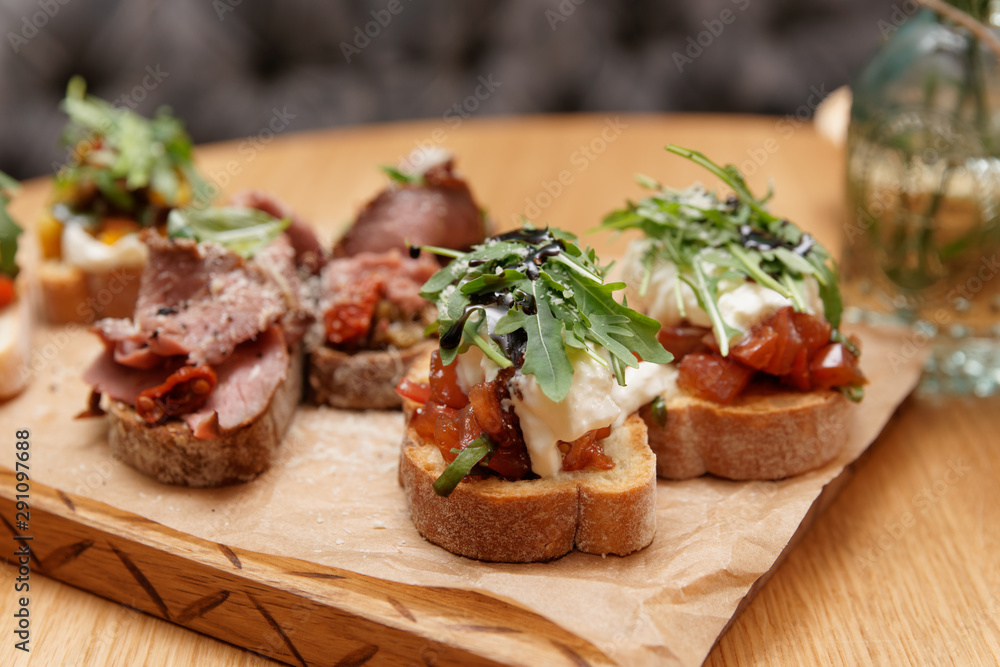 Bruschettas with beef, tomatoes and cheese, close-up