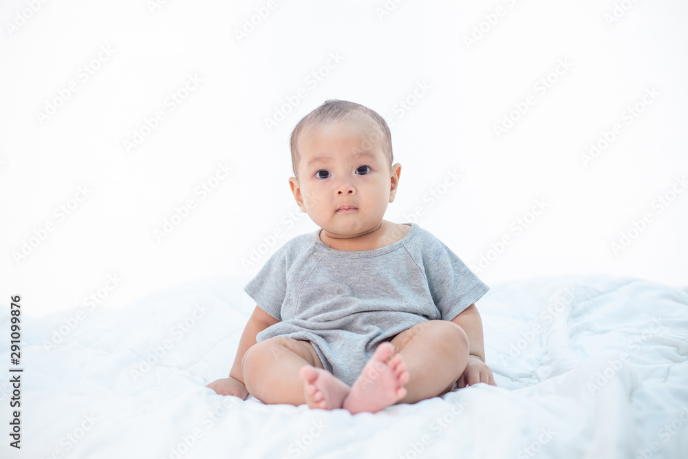 The little boy sitting on the bed