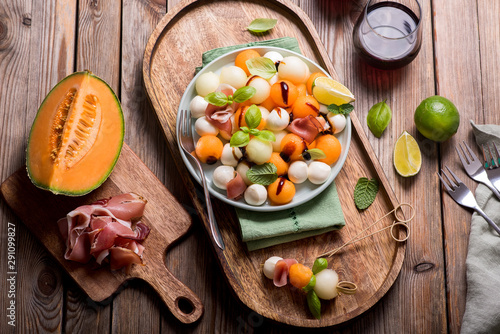 Melon, mozzarella, prosciutto appetizer or snack, summer salad with cantaloupe melon photo