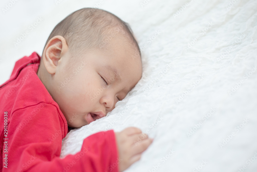 Babies wearing red shirts sleeping in bed Babies wearing red shirts sleeping in bed