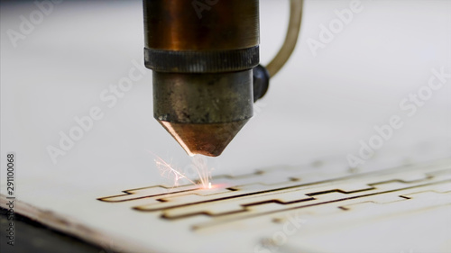 Industrial laser is cutting a pattern on a plywood sheet