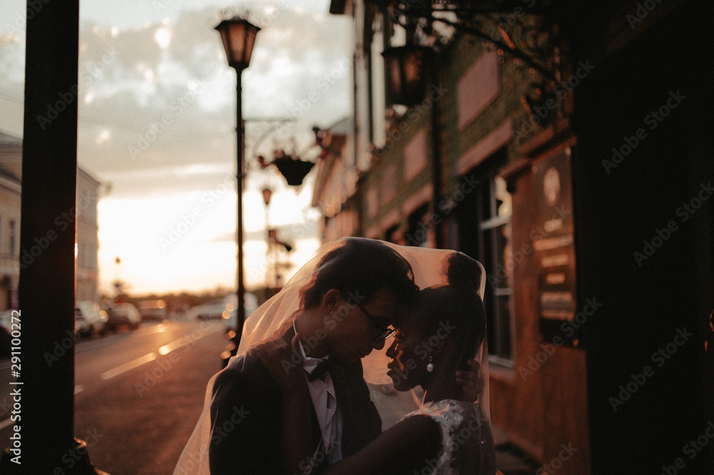 Bride and groom hugging in the town street. Interracial marriage. Asian bride and groom. Bride and groom hugging in the town street. Interracial marriage. Asian bride and groom.