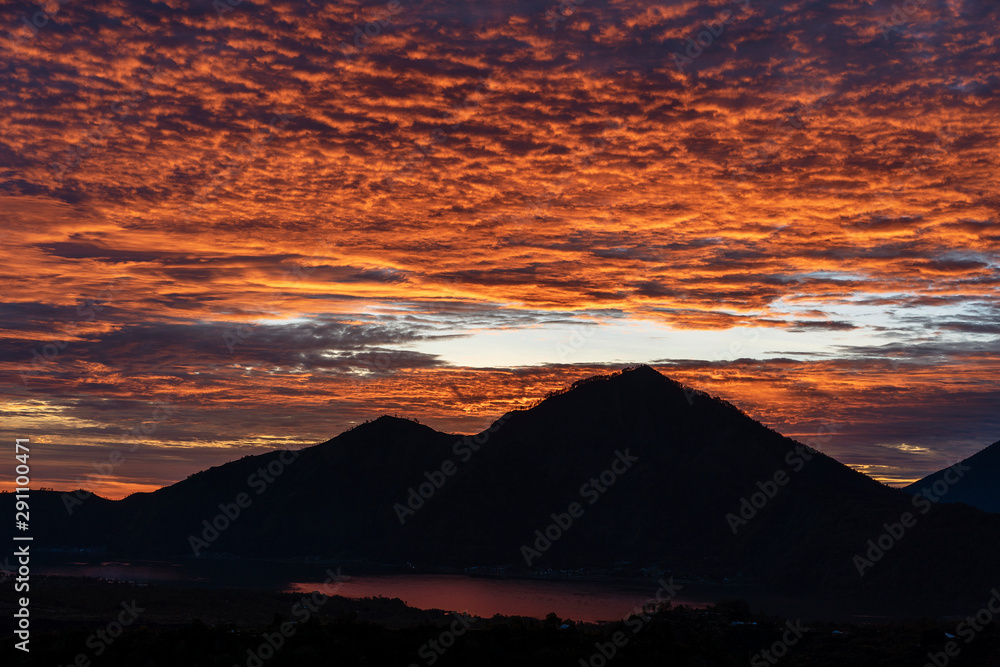 Cloudy landscape with silhoutte of volcano mountains on sunrise. Bali, Indonesia