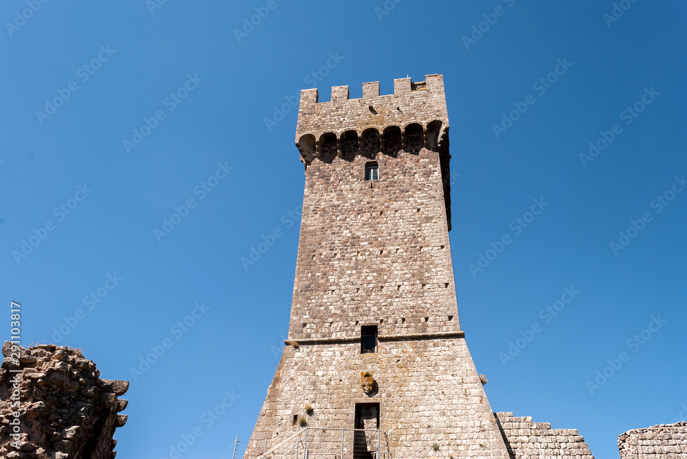 Torre medievale italiana antica in pietra e mattoni ripresa dal basso