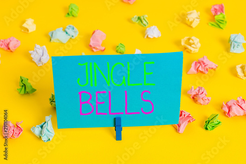 Writing note showing Jingle Bells. Business concept for Most famous traditional Christmas song all over the world Colored crumpled paper empty reminder white floor clothespin