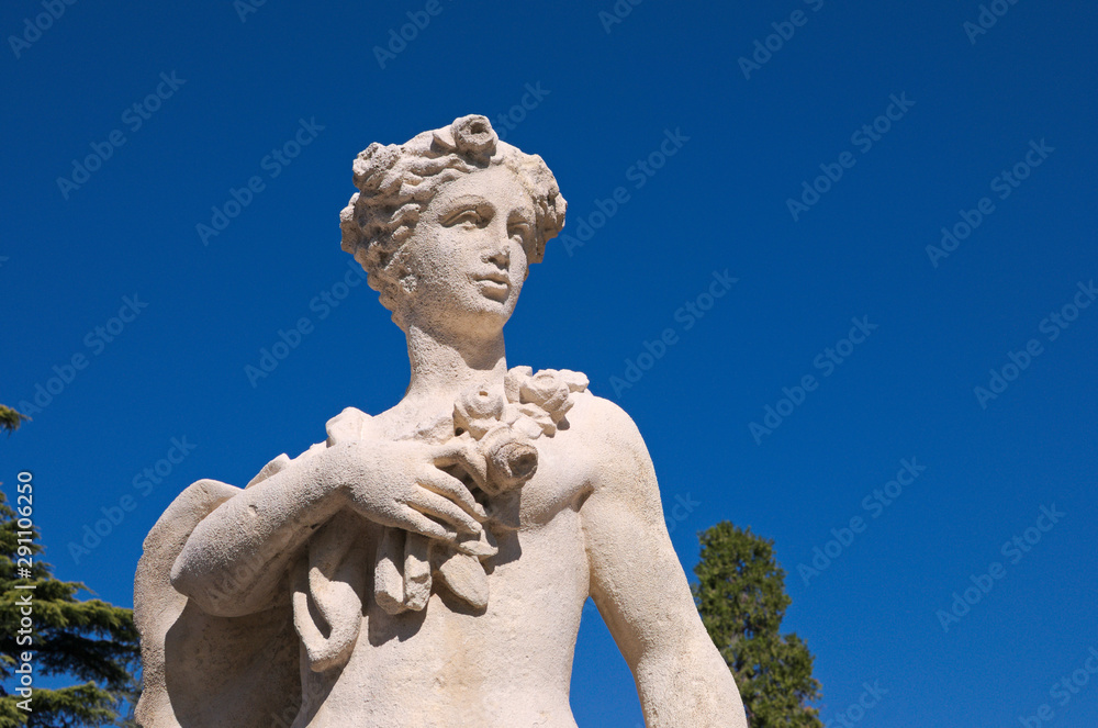 classical statue against blue sky