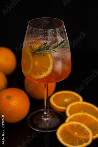 summer cocktail with ice and oranges on a black background