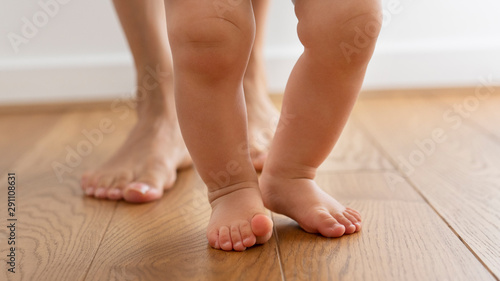 Fotografia Close Up Of Mother Helping Baby Son To Take First Steps At Home