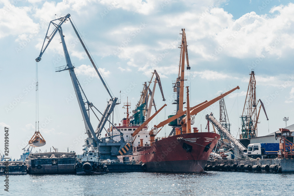 Port cranes and equipment for loading and unloading cargo. The concept of transportation of goods by water.