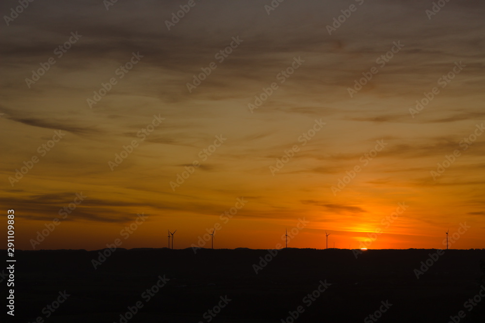 Beautiful sunset between wind turbines on the horizon