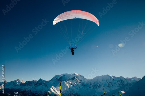 Paraglider silhouette in French Alps.