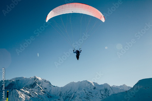 Paraglider silhouette in French Alps.