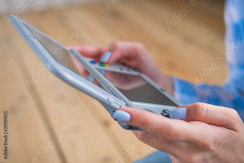 Close up view of woman hand using grey handheld game console at home. Gaming, hobby, technology, entertainment, portable, video game and leisure time concept