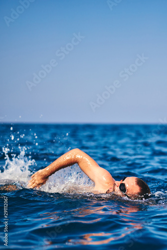 Swimmer training on the open sea / ocean.