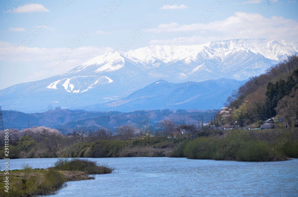 Landscape view of the mountain range with snow on the mountain in spring daytime with shiroishi river in foreground