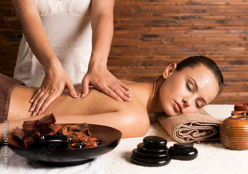 Woman with closed eyes having massage of body.