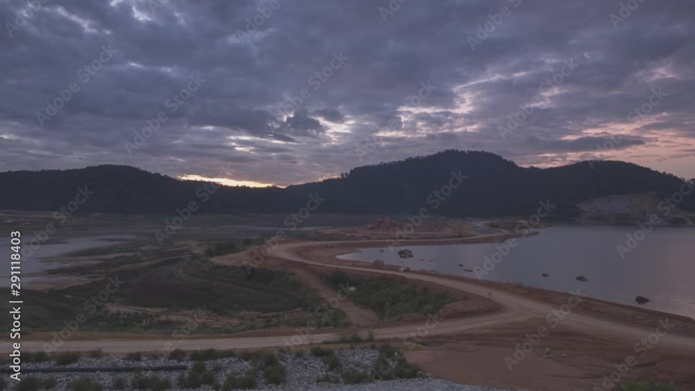 Timelaps moving cloud over S shape road in the construction in the morning. The bulldozer and excavator is in action. Timelaps moving cloud over S shape road in the construction in the morning. The bulldozer and excavator is in action.