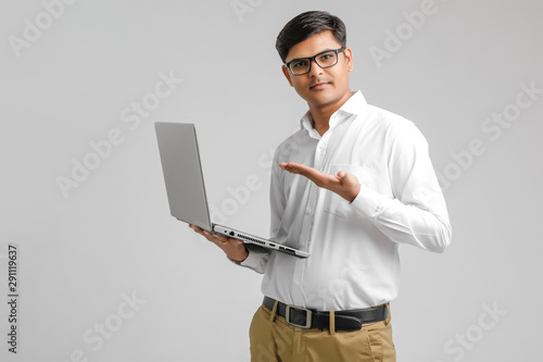 handsome Indian / Asian male student using laptop, isolated on white background