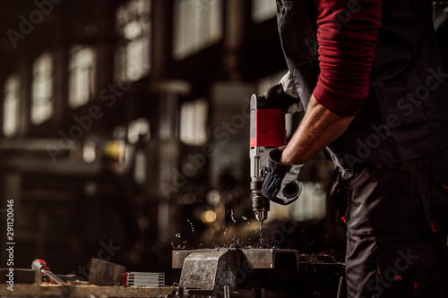 Man drilling in metal, hand drill