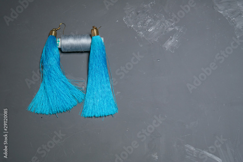 Blue serigi tassels with blue threads on a gray background © LenN
