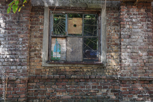 Fototapeta Naklejka Na Ścianę i Meble -  Vintage old window with lattice metal bars on the wall facade