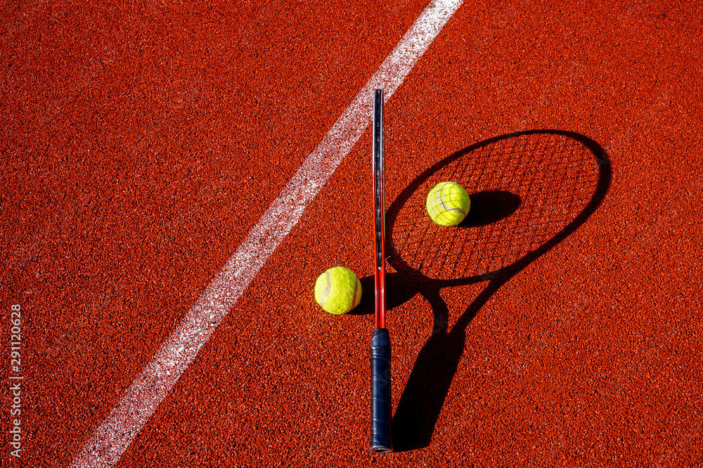 Tennis balls and racket on an outdoor court