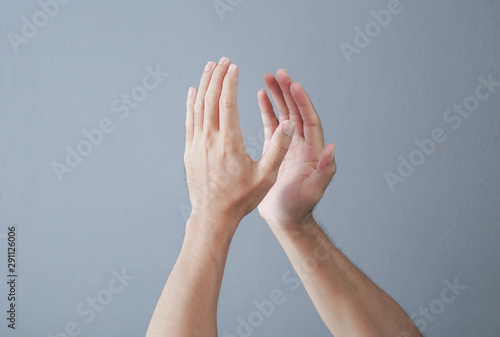 Fotografía Man clapping hands on grey background