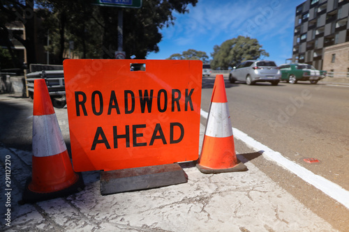 Canvas Print Red road work infrastructure repair ahead symbol sign applying on busy business