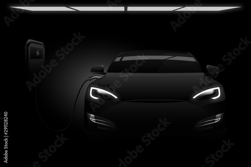 Black electric car with a charging station in the dark. © scharfsinn86