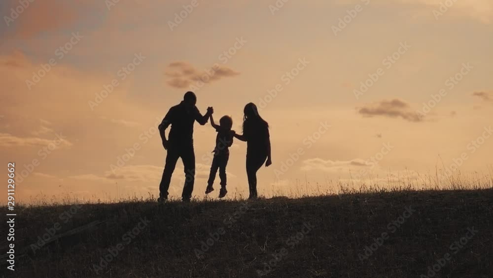 happy family father, mother and son outdoors silhouette concept slow motion video. dad man mom girl hold little boy son by hands. little boy jumping silhouette at sunset outdoors. happy lifestyle happy family father, mother and son outdoors silhouette concept slow motion video. dad man mom girl hold little boy son by hands. little boy jumping silhouette at sunset outdoors. happy lifestyle