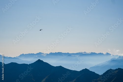 View over the swiss alps bernese oberland, with helicopter over the mountains