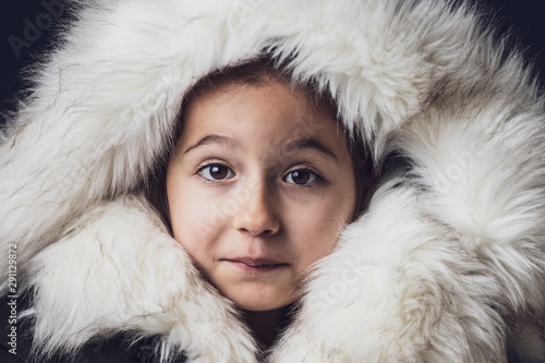 Close up portrait of a young girl dressed with an eskimo jacket  looking at the camera photo