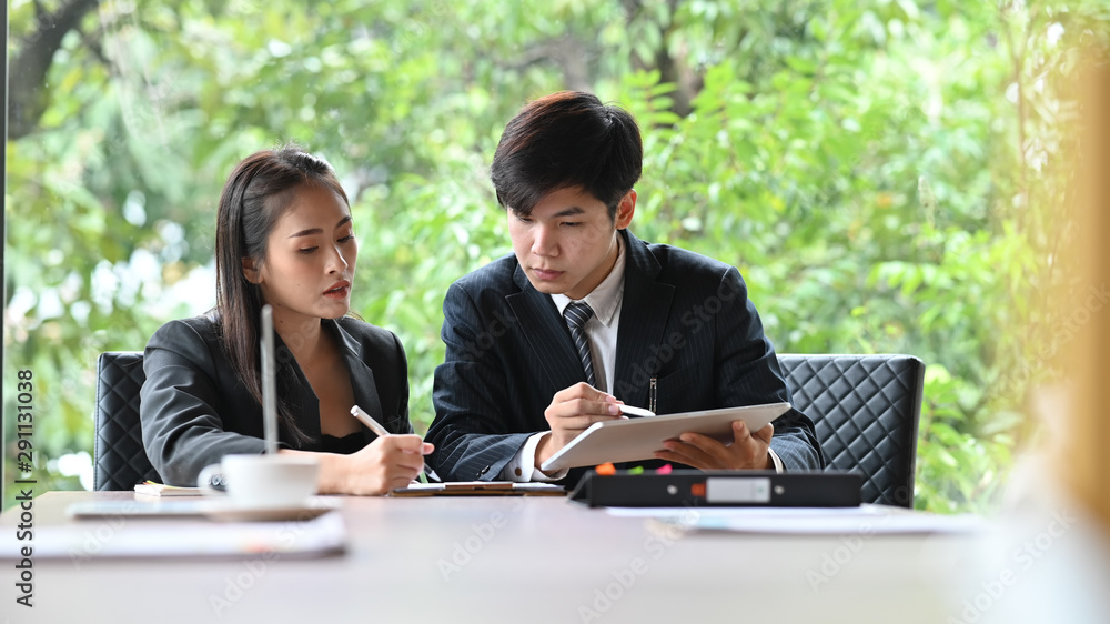 Asian young business people meeting with tablet on modern office table. Asian young business people meeting with tablet on modern office table.