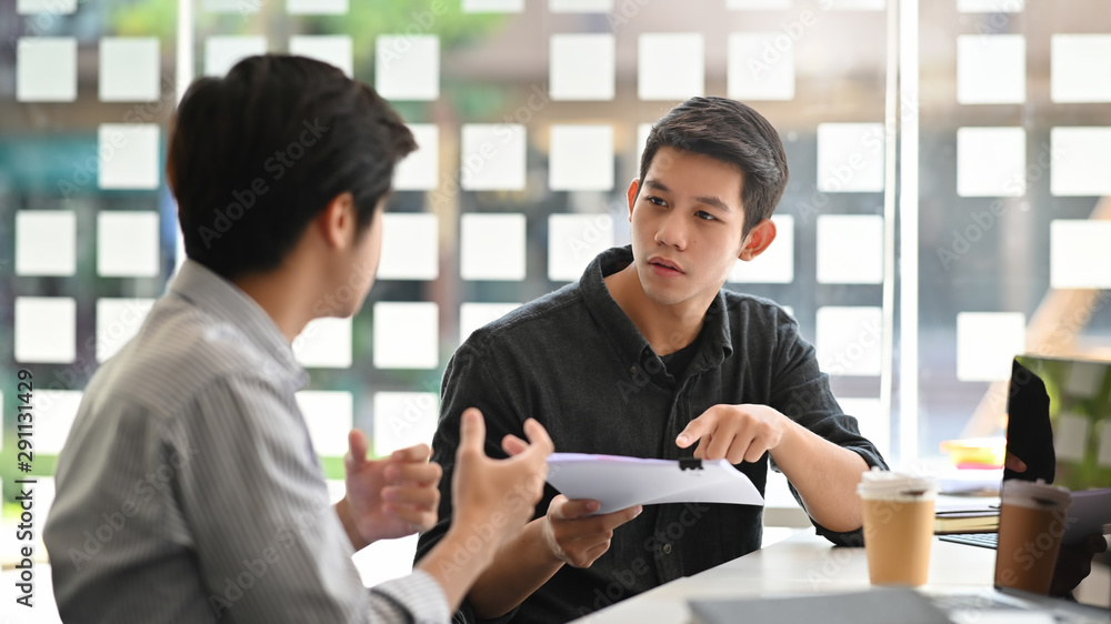 Asian young man consulting with paper document on modern office. Asian young man consulting with paper document on modern office.