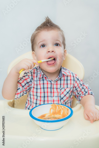 baby in the kitchen eating fruit puree