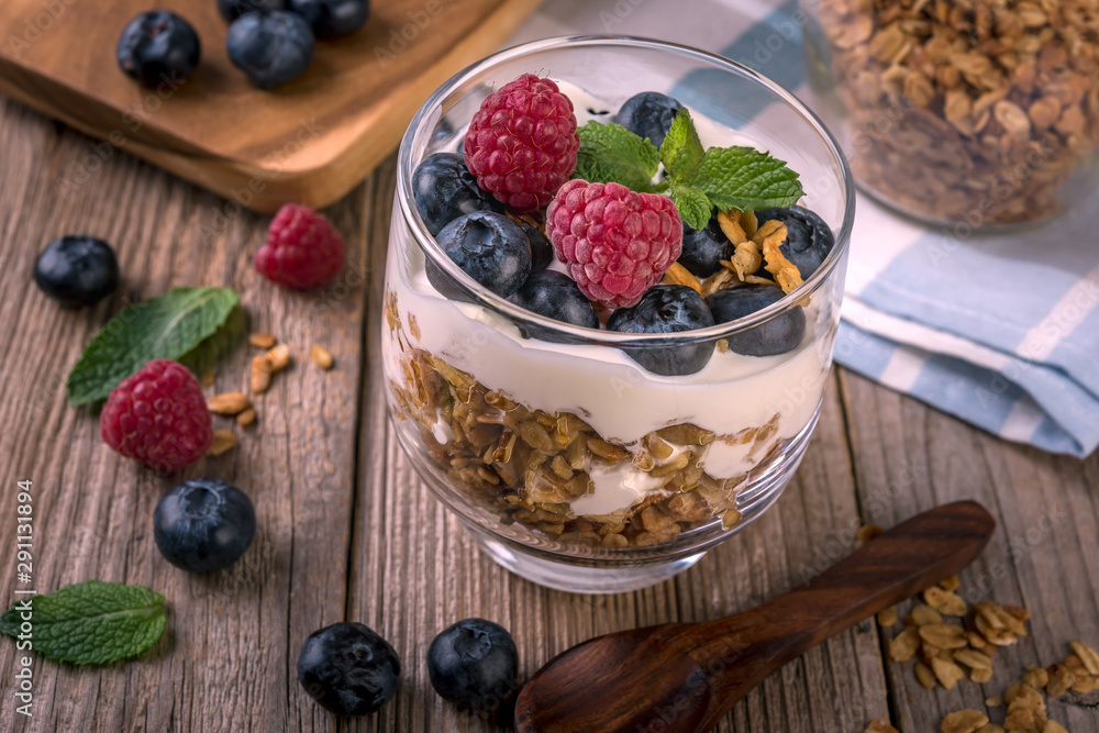 granola with yogurt and fresh blueberries in a glass on wooden background granola with yogurt and fresh blueberries in a glass on wooden background