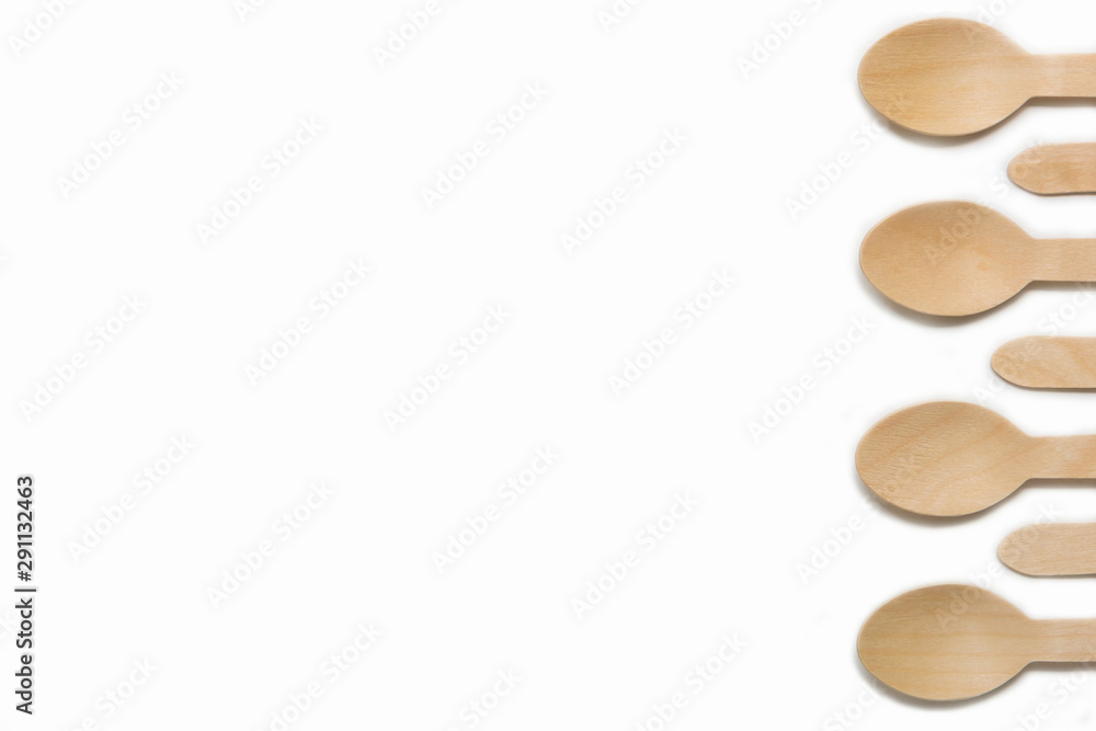 Disposable wooden cutlery spoon isolated on white background. The concept zero waste, of environmental protection, save nature, ecology plastic free. Pattern with place for text Disposable wooden cutlery spoon isolated on white background. The concept zero waste, of environmental protection, save nature, ecology plastic free. Pattern with place for text