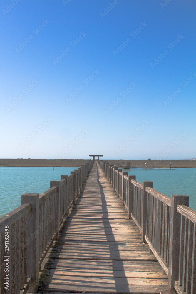 Wooden walkway brigde over river mouth and marsh