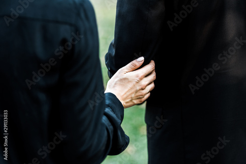 cropped view of woman touching senior man on funeral