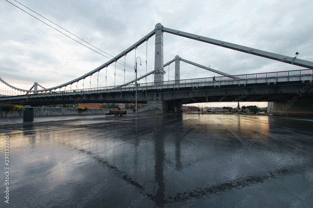 Obraz premium Moskva river embankment in the rainy autumn day. Krymsky Bridge over Moskva river from Gorky park. Walking and resting people. Fish eye technique/lens.