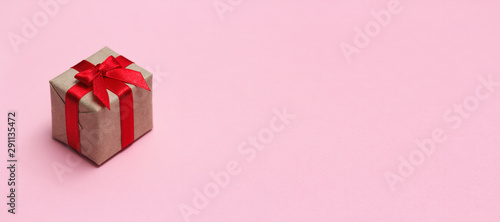 Single gift box on pink solid background. Sale concept. Long horizontal banner photo format.	